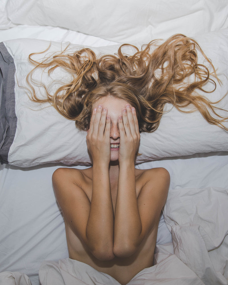 Happy woman stretching in bed after quality sleep symbolizing energy and wellness from Nutreska Clinical sleep supplements